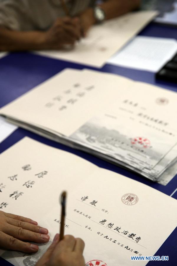 Retired lecturers write admission notices with writing brush, as a special gift for the newly-recruited students of Shaanxi Normal University, in Xi'an City, northwest China's Shaanxi Province, July 15, 2013. Unlike the printed university adimission notice issued by most of universities in China, Shaanxi Normal University organized more than 20 retired lecturers to write the notice by hand this year. China's annual university recruitment is underway. (Xinhua/Hou Zhi)