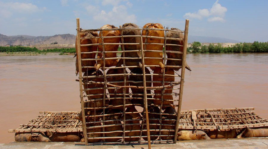 A raft made of inflated sheepskin and wooden beams is ready to go down the Yellow River. In Gansu Province's Jingtai County, traditional rafts are created by the traditional method. Today the rafts are most commonly used to take tourists on picturesque 30 minute cruises down the Yellow River. (Photo: CRIENGLISH.com/William Wang)