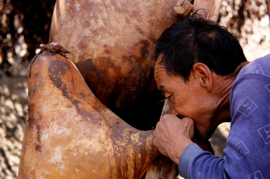 In Gansu Province's Jingtai County, a raftsman blows air into sheepskin to apply pressure. In Gansu Province's Jingtai County, traditional rafts are created by the traditional method. Today the rafts are most commonly used to take tourists on picturesque 30 minute cruises down the Yellow River. (Photo: CRIENGLISH.com/William Wang)