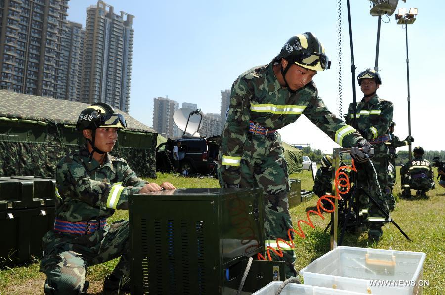 Soldiers install an equipment in a rescue drill held in Hangzhou of east China's Zhejiang Province, July 17,2013. The emergency drill was held on Wednesday to improve the reaction capability against typhoon. (Xinhua/Ju Huangzong) 