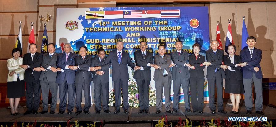 Ministers and officials of the Association of Southeast Asian Nations (ASEAN) countries hold hands together with ASEAN Secretary-General Le Luong Minh (5th L) during the 15th Ministerial Steering Committee Meeting on Transboundary Haze Pollution in Kuala Lumpur, Malaysia, on July 17, 2013. Officials from the haze-inflicted Southeast Asian countries tried to make joint effort to end the heavy smog that troubles the region despite differences at a ministerial meeting here on Wednesday. (Xinhua/Chong Voon Chung)