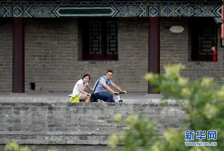 Tourists visit the ancient city wall of Xi'an in northwest China's Shaanxi province, July 10, 2013. (Xinhua/Li Yibo)