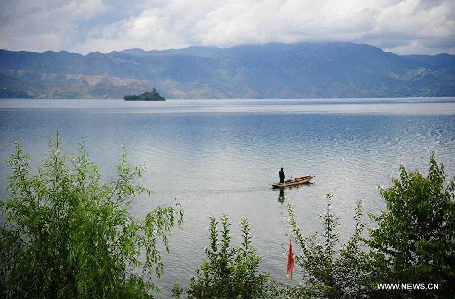 People fish on the Lugu Lake in the Yi Autonomous County of Ninglang, southwest China's Yunnan Province, July 17, 2013. Lugu is renowned for its beautiful scenery and the maintenance of the unique matriarchal system observed by the indigenous Mosuo people. . (Xinhua/Qin Lang)