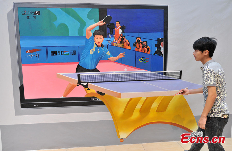 Photo taken on July 18 shows a visitor has fun at a 3D art exhibition in Fuzhou of Fujian Province. More than 40 3D magic paintings are shown to the public at the exhibition. (CNS /Lv Ming)