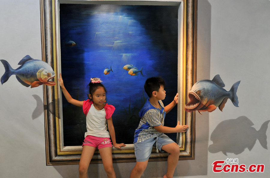 Photo taken on July 18 shows a visitor has fun at a 3D art exhibition in Fuzhou of Fujian Province. More than 40 3D magic paintings are shown to the public at the exhibition. (CNS /Lv Ming)