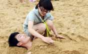 Tourists enjoy coolness of beach in E China