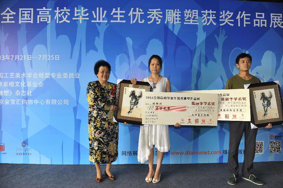 Chan Laiwa (L), president of the Hong Kong-based Fuwah International HK Group, presents "Chan Laiwa academic award" to students at the award ceremony of an exhibition of the awarded sculpture works of 2013 college graduates in Beijing, capital of China, July 21, 2013. These awarded works are presented to the public from July 21, 2013 to July 25, 2013 here. (Xinhua/Lu Peng)