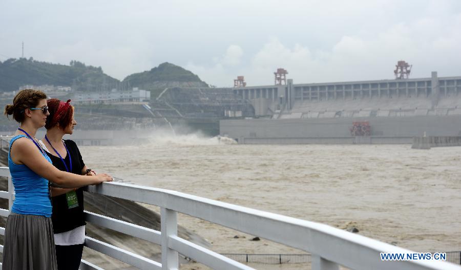 Visitors watche flood water discharged from the Three Gorges Dam, a gigantic hydropower project on the Yangtze River, central China's Hubei Province. The Yangtze River, China's longest, braced for its largest flood peak so far this year due to continuous rainfall upstream. Water flow into the reservoir of the Three Gorges Dam reached 49,000 cubic meters per second on Sunday morning. (Xinhua/Lei Yong)