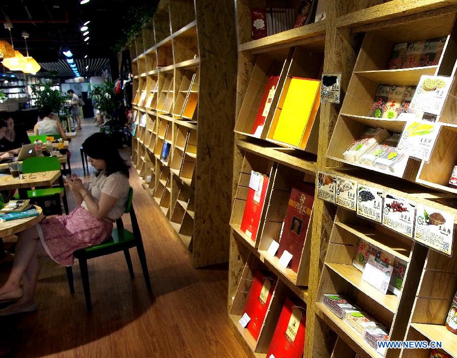 Customer rests in an entity bookstore on Changshu Road in east China's Shanghai, July 21, 2013. Some new style entity bookstores in Shanghai are opened with beverage, food supply and stationery selling. These customer-oriented bookstores bring a new idea for selling books and attract many customers to spend time on reading here. (Xinhua/Chen Fei)