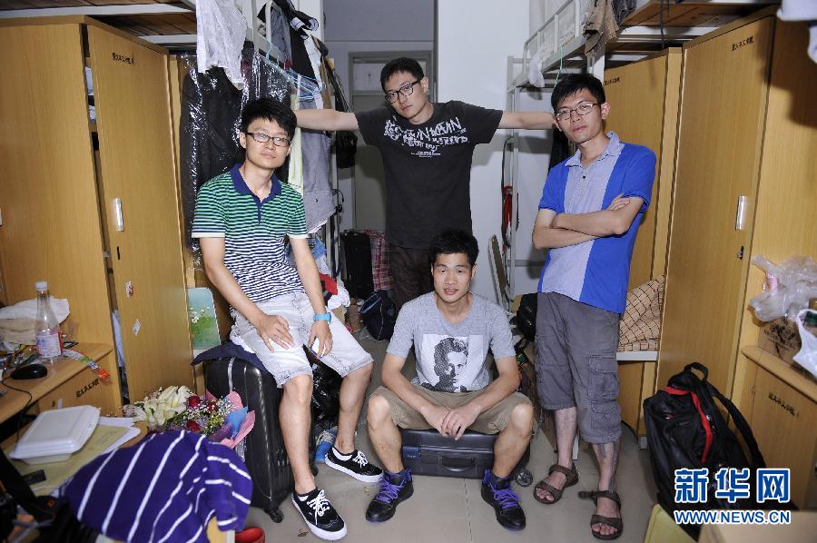 Yan Lifei (middle back), Guo Jiaxuan (left), Hu Xunguang (middle before), Gao Jingning (right), take a group photo in Room 1009, Jingshen Building, Jinan University, Guangzhou, July 1, 2013. (Xinhua/Liang Xu)