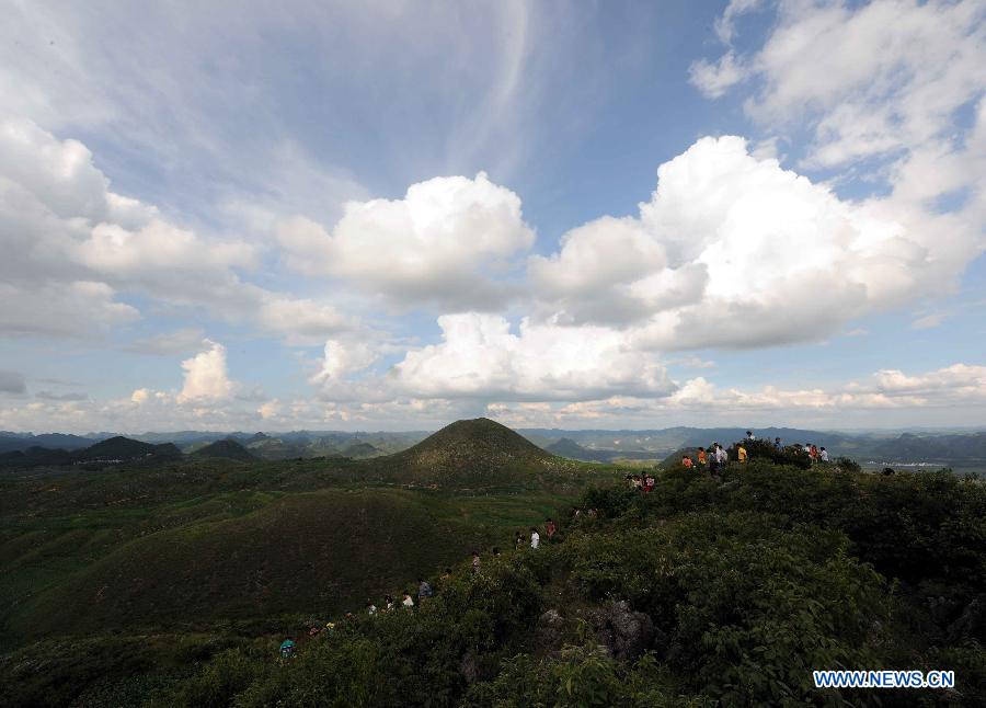Tourists visit the Puzhehei scenic area in Qiubei County, southwest China's Yunnan Province, July 20, 2013. Known as "the unique pastoral scenery in China", the beauty spot attracts a large number of tourists with 380 mountain peaks, 83 karst caves, 54 lakes and 2,667 hectares of wetlands. (Xinhua/Yang Zongyou)