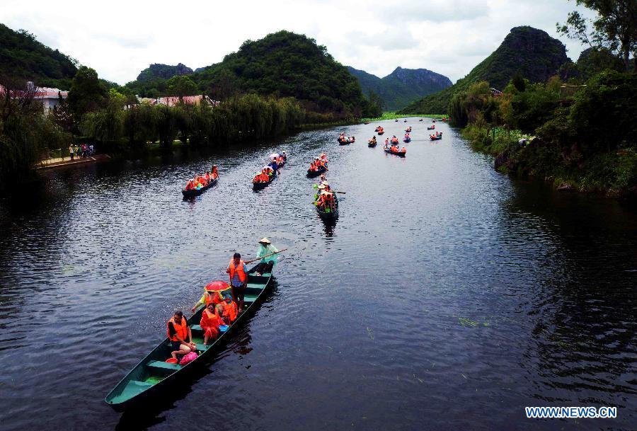 Tourists visit the Puzhehei scenic area in Qiubei County, southwest China's Yunnan Province, July 18, 2013. Known as "the unique pastoral scenery in China", the beauty spot attracts a large number of tourists with 380 mountain peaks, 83 karst caves, 54 lakes and 2,667 hectares of wetlands. (Xinhua/He Han)