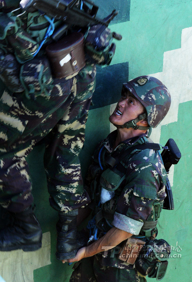 The special operation members help each other to climbing the wall. (Xinhua/Wang Jianmin)