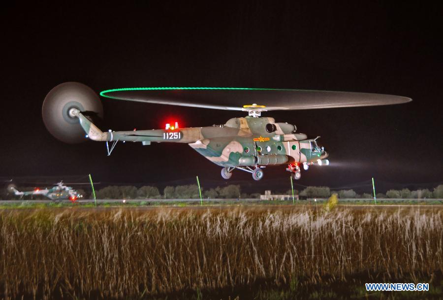 A helicopter of China's PLA Air Force takes part in a night flight training at an airport in Lhasa, capital of southwest China's Tibet Autonomous Region, July 22, 2013. This is the first time for the PLA Air Force to hold such training. (Xinhua/Li Liangfeng)