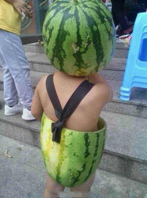 A kid beats summer heat by covering the body with the skin of half a watermelon in Wenzhou, east China's Zhejiang province. (Photo/ people.com.cn)