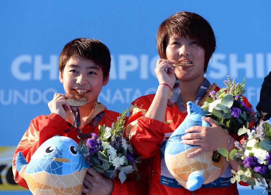 China's Chen Ruolin (R) and Liu Huixia celebrate during the awarding ceremony after the women's 10m synchro platform final of the 15th FINA World Championships in Barcelona, Spain, on July 22, 2013. Chen Ruolin and Liu Huixia won the gold medal with a total score of 356.28 points. (Xinhua/Guo Yong)