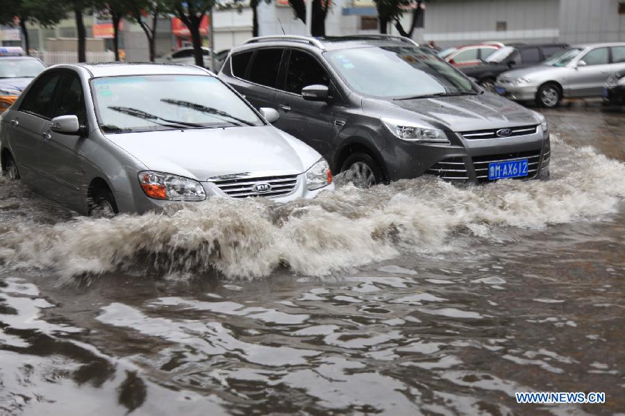 Vehicles run on a flooded road in Binzhou City, east China's Shandong Province, July 23, 2013. Heavy rainfall hit parts of the province in these two days. (Xinhua/Liu Chunying)