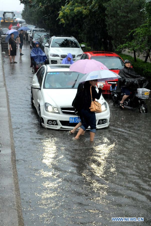 Traffic is disrupted on the waterlogged Shengchan Road in Jinan, capital of east China's Shandong Province, July 23, 2013. A heavy rainfall hit Jinan on Tuesday. (Xinhua/Xu Suhui)