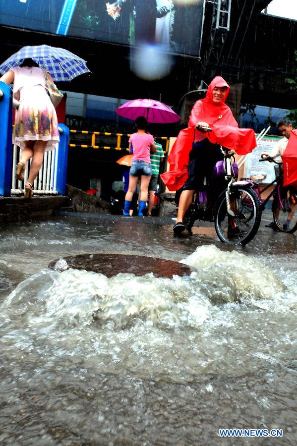Shengchan Road is waterlogged in Jinan, capital of east China's Shandong Province, July 23, 2013. A heavy rainfall hit Jinan on Tuesday. (Xinhua/Xu Suhui)