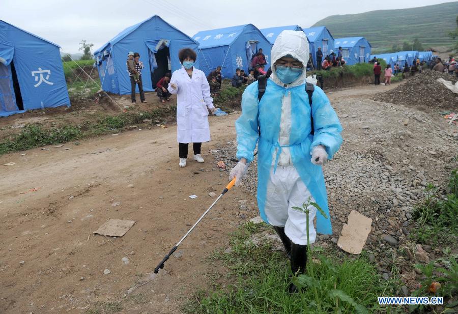 A medical worker sprays disinfectant at a temporary settlement to prevent epidemic at quake-hit Yongguang Village of Minxian County, northwest China's Gansu Province, July 23, 2013. The death toll has climbed to 94 in the 6.6-magnitude earthquake which jolted a juncture region of Minxian County and Zhangxian County in Dingxi City Monday morning. (Xinhua/Luo Xiaoguang)