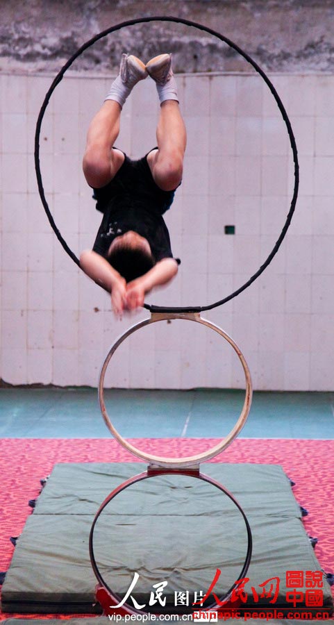 A child in the acrobatic troupe do daily trainings. (vip.people.com.cn/Liang Hongyuan)