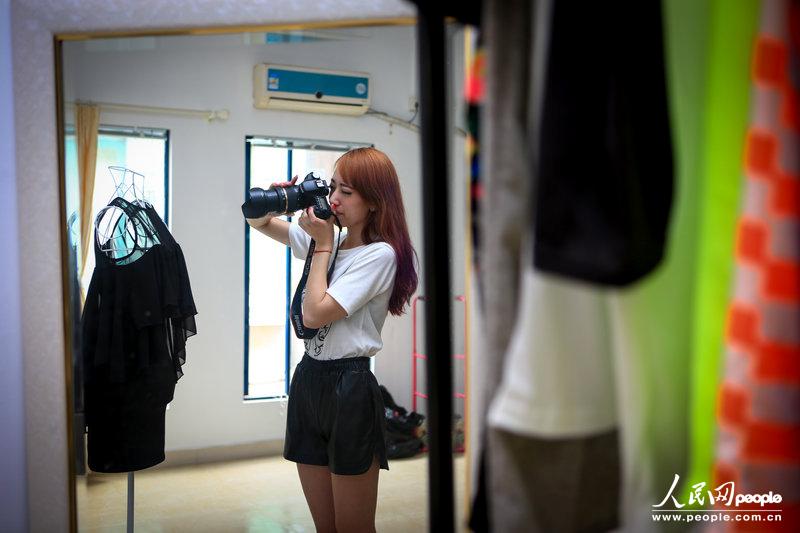 Wang take photos of the clothes. (Photo/CFP)