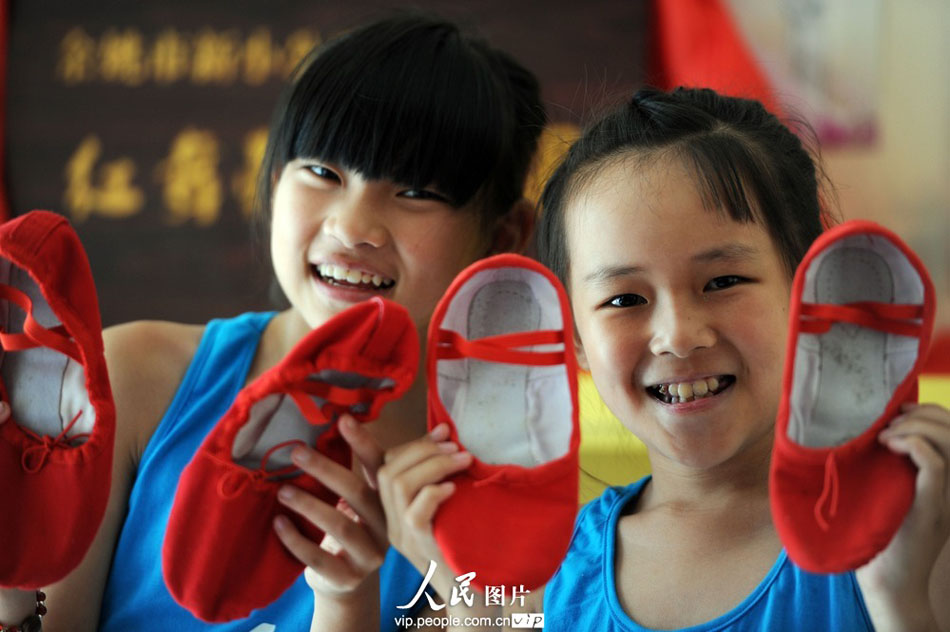 Sun Yuling (L) from Chongqing and Luo Zidan (R) from Jiangxi province present their new pairs of red pumps for dance. (Photo by Chen Binrong/ vip.people.com.cn)