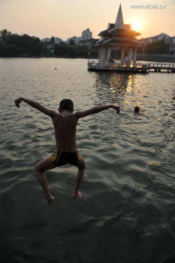 A boy jumps to the lake to cool himself off at the Huancheng Park in Hefei, capital of east China's Anhui Province, July 24, 2013. (Xinhua/Yang Xiaoyuan) 