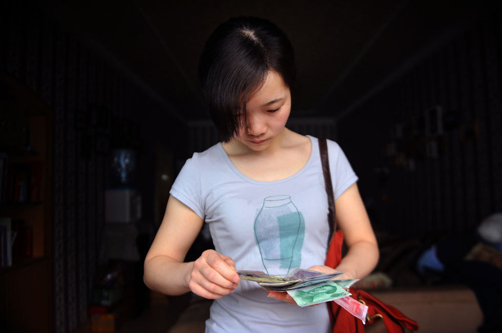Niuniu works in a design company. She counts her money every day before leaving home, saying that it helps develop good financial habits. (Qianzhong Morning News/Yang Xingbo)
