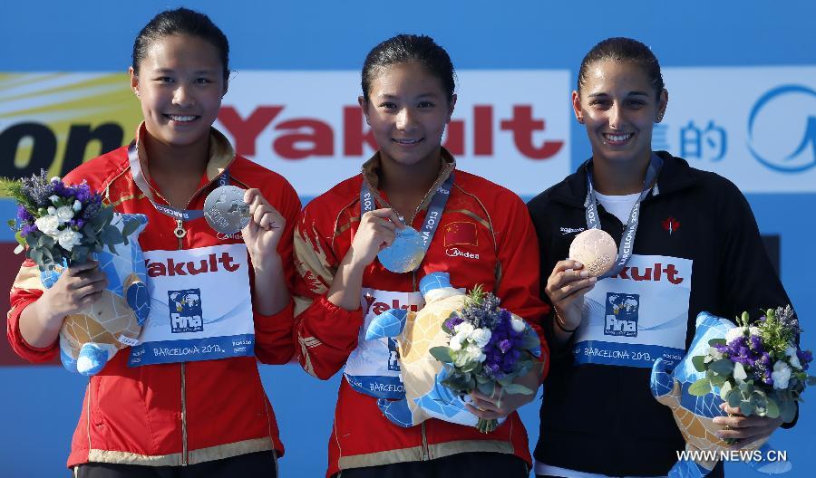 Gold medalist China's He Zi (C), her teammate silver medalist Wang Han and bronze medalist Pamela Ware of Canada pose for pictures during the awarding ceremony for Women's 3m Springboard diving at the 15th FINA World Championships in Barcelona, Spain, on July 27, 2013. He Zi claimed the title with a total score of 383.40 points. (Xinhua/Wang Lili) 