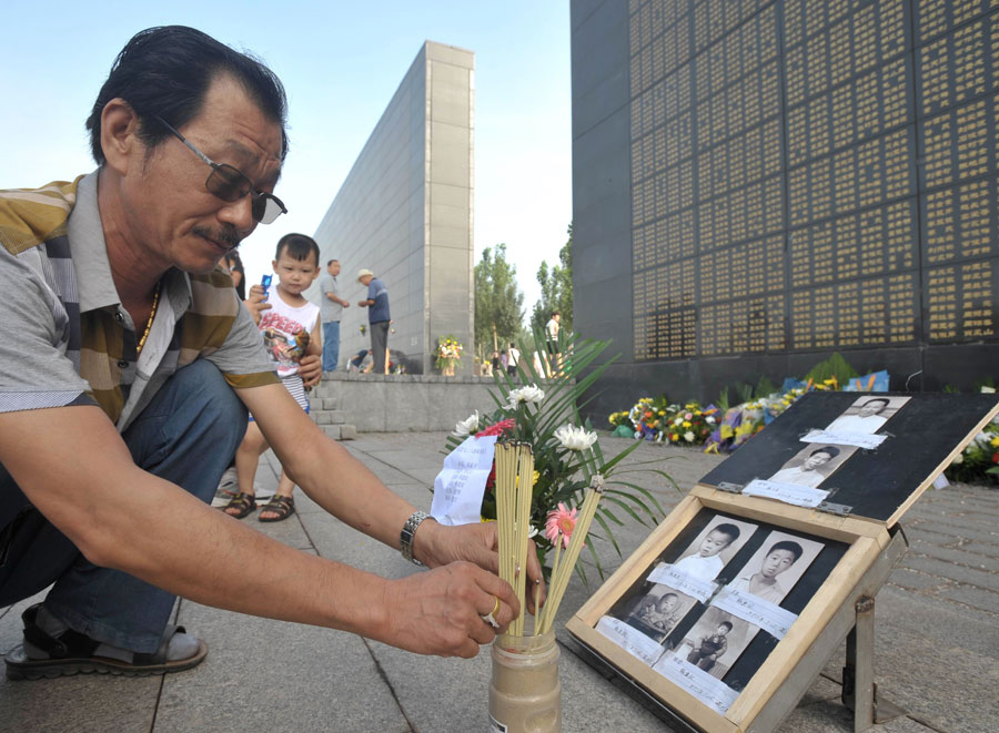 A man mourns for his relatives died in the 1976 Tangshan earthquake in front of the memorial wall in Tangshan, north China's Hebei Province, July 28, 2013. Local residents came to the memorial park on Sunday to commemorate the 37th anniversary of the Tangshan earthquake. (Photo/Xinhua)