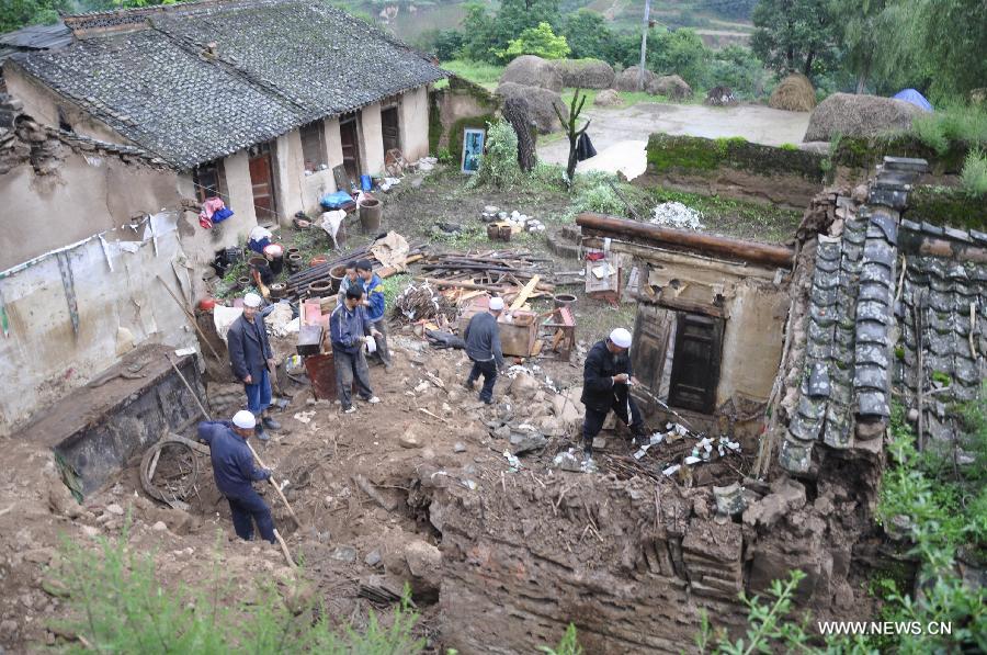Residents clear the debris of their damaged houses in rainstorm-hit Haiwan Village of Zhangjiachuan Hui Autonomous County in northwest China's Gansu Province, July 28, 2013. (Xinhua/Dou Miaomiao)