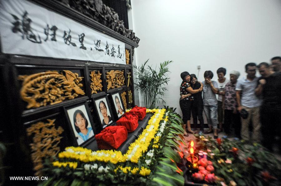 Relatives of three Chinese teenager girls, who were killed in an Asiana airliner crash three weeks ago, mourn at the Jiangshan Municipal Funeral Parlour in Jiangshan, east China's Zhejiang Province, July 29, 2013. The ashes of the three Chinese teenagers were sent to the city of Jiangshan, their hometown, on Monday. The girls were aboard Asiana Airlines Flight 214 when it crashed at San Francisco International Airport on July 6. The crash killed one of the girls instantly, while another girl was run over by an ambulance. The third girl died six days later in a local hospital after sustaining critical injuries. (Xinhua/Han Chuanhao) 