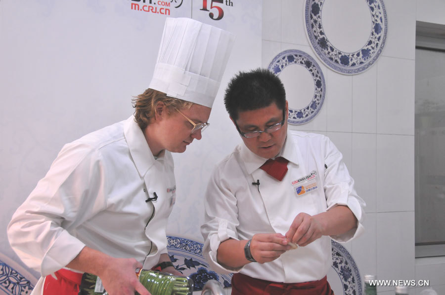 Nick Gollner from U.S. gets advice from judge during "Chopsticks and Beyond" Cantonese Cuisine Competition on June 27, 2013. "Chopsticks and Beyond" is a Chinese cuisine challenge launched by CRIENGLISH.com to provide a platform for foreign food enthusiasts to show off their Chinese cooking skills and explore creative dishes with exotic flavor. It features China's four great traditions: Sichuan Cuisine, Cantonese Cuisine, Shandong Cuisine and Huaiyang Cuisine. (Xinhuanet/Yang Yi)