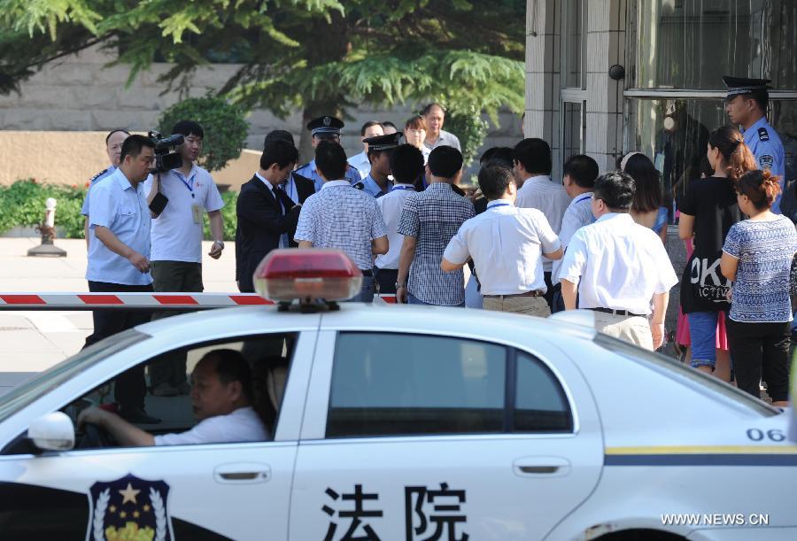 People walk into the Shijiazhuang Intermediate People's Court in Shijiazhuang, north China's Hebei Province, July 30, 2013. The court on Tuesday opened a trial for a man who allegedly added poison to frozen dumplings that sickened 10 people in Japan in 2008. (Xinhua/Wang Min) 