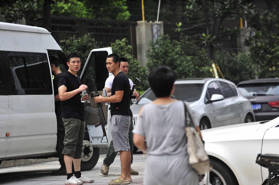 Policemen are seen at the accident site of a gun fight with drug dealers in the Chenghua District of Chengdu, capital of southwest China's Sichuan Province, July 31, 2013. A gun fight took place as drug dealers resisted arrest from the police. One suspect jumped from a building and was killed while another two were arrested. (Xinhua/Xue Yubin)