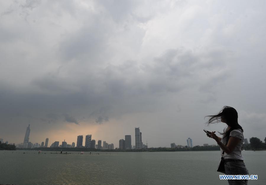 Buildings are shrouded by dark clouds in Nanjing, capital of east China's Jiangsu Province, July 31, 2013. An artificial precipitation brought coolness to citizens in Nanjing. (Xinhua/Lang Congliu)