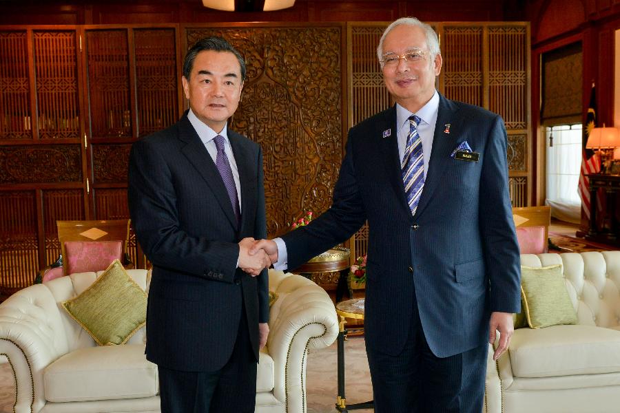 Malaysian Prime Minister Nazib Tun Razak (R) shakes hands with visiting Chinese Foreign Minister Wang Yi in Putrajaya, Malaysia, Aug. 1, 2013. (Xinhua/Chong Voon Chung)