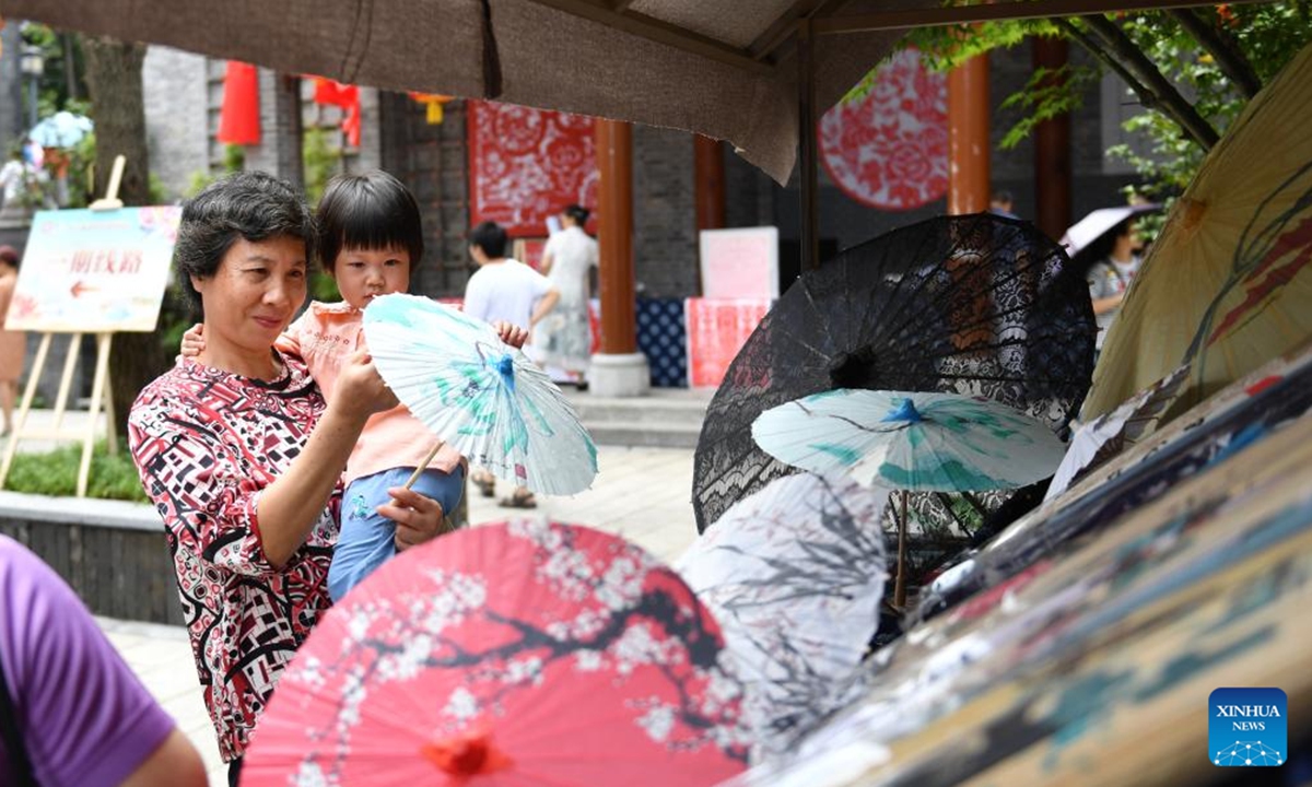 This photo taken on Sept. 16, 2023 shows visitors shop at the intangible cultural heritage exhibition held in Scroll Town in Suxian District of Chenzhou City, central China's Hunan Province. (Xinhua/Chen Zhenhai)