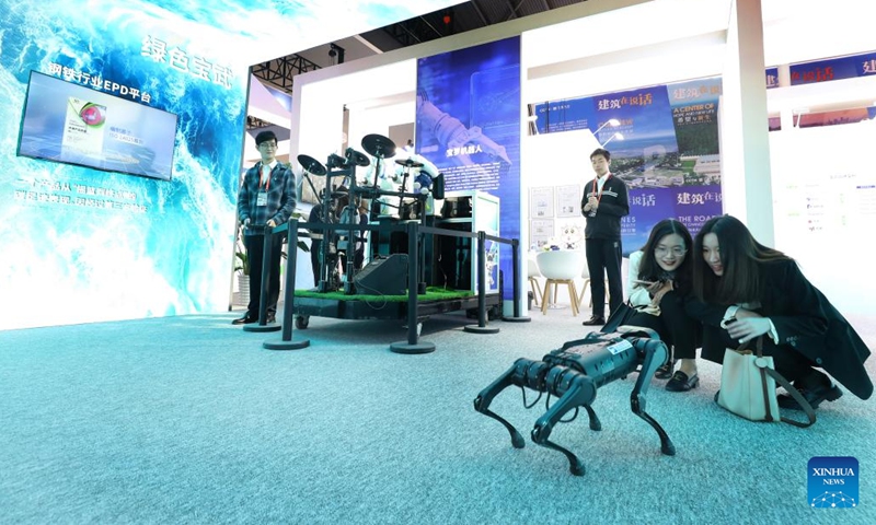Visitors interact with a four-legged robot at the Exposition on China Brand 2023 in east China's Shanghai, May 10, 2023. The Exposition on China Brand 2023 kicked off Wednesday at the Shanghai World Expo Exhibition and Convention Center. Around 1,000 Chinese enterprises participated in the exposition, showcasing the new look of current Chinese brands to the world.(Photo: Xinhua)